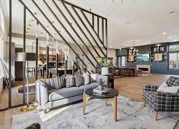 A living room with a grey sofa, a black and white checkered armchair, and a wooden coffee table.