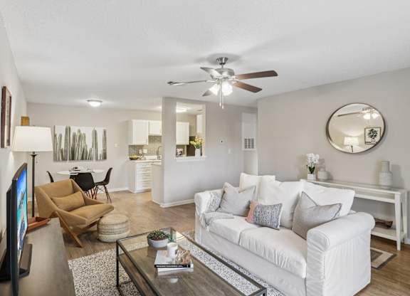 A living room with a white couch and a flat screen TV.