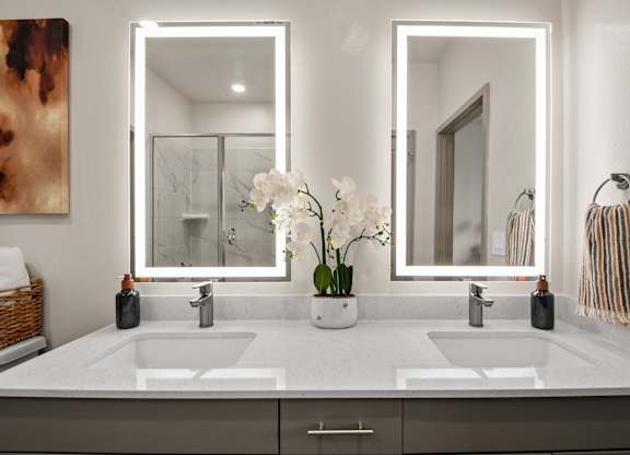 A bathroom with two sinks and two mirrors.