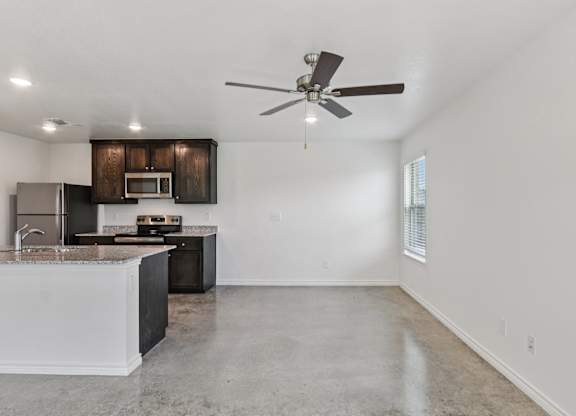 A kitchen with a white countertop and a ceiling fan.