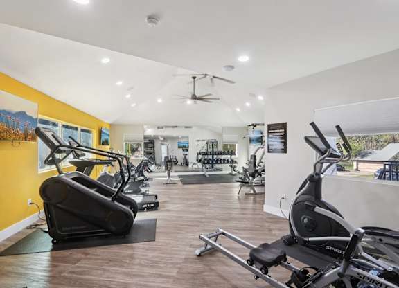 A gym with treadmills, elliptical machines, and other exercise equipment.