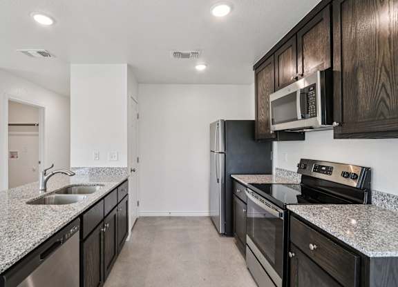 A kitchen with black cabinets and stainless steel appliances.
