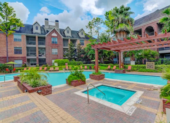 A large building with a pool in front of it.