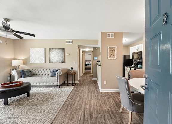A living room with a couch, a coffee table, and a ceiling fan.