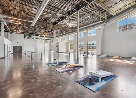 A spacious room with a high ceiling and large windows.