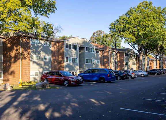 A parking lot with cars and apartment buildings.