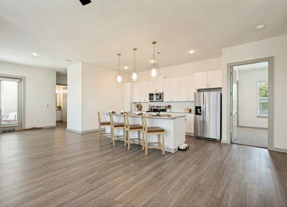 A kitchen with a dining table and chairs in the middle of the room.