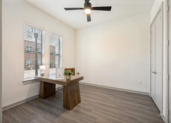 A room with a table and a fan.