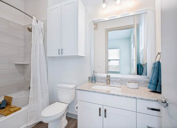 A white bathroom with a toilet, sink, and shower.