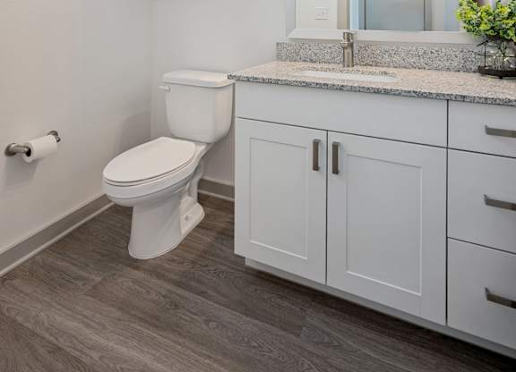 A bathroom with a toilet, sink, and medicine cabinet.
