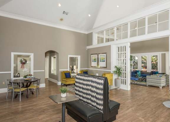 a living room with a couch and a chair in front of a table with a plant on