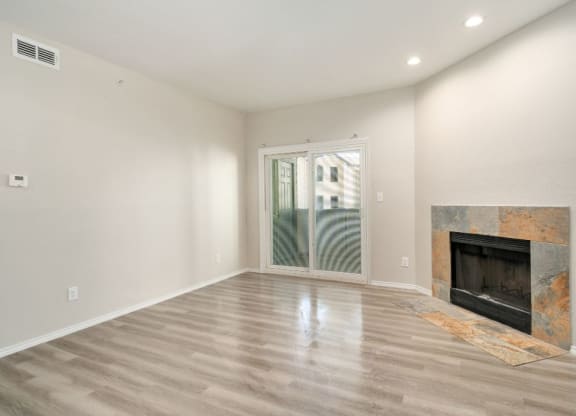 a living room with a fireplace and a door to a balcony