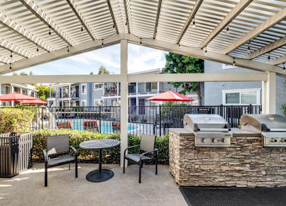 A patio with a grill and seating area.