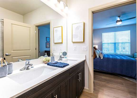 A bathroom with a blue bedroom in the background.