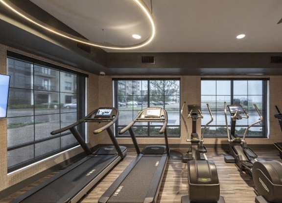 A gym with treadmills and elliptical machines.