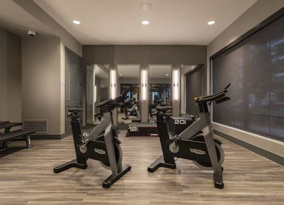 A gym with a treadmill and a bench.