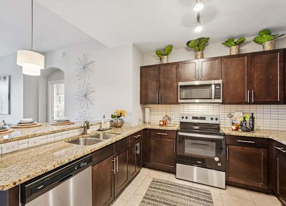 A modern kitchen with brown cabinets and stainless steel appliances.