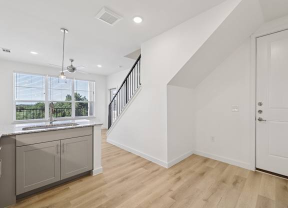 A kitchen with a window and a staircase.