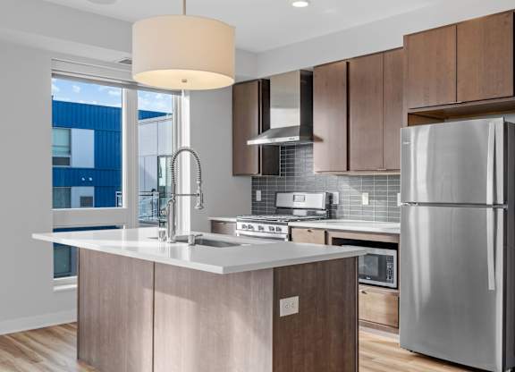 A modern kitchen with a large island and stainless steel appliances.