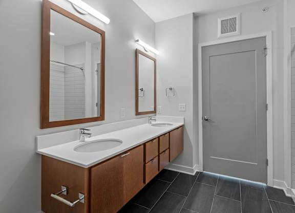 A bathroom with a sink, mirror, and wooden cabinets.