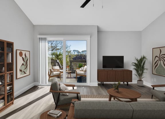 a living room with a couch and a tv and a balcony