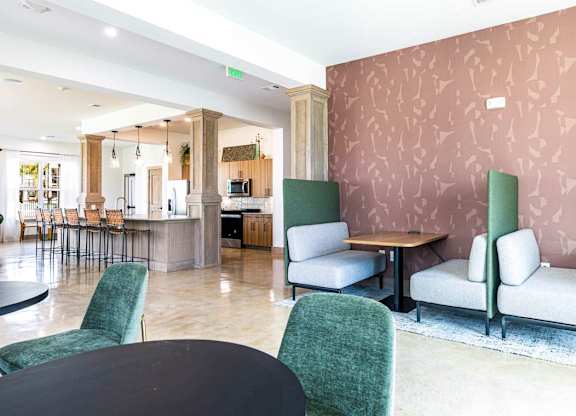 A room with a pink wallpaper and a green chair.