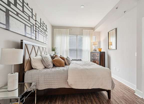 A bedroom with a large bed and a painting on the wall.