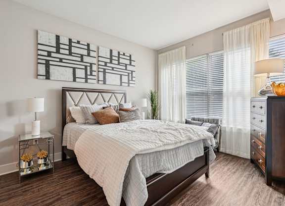 A bedroom with a large bed and a painting on the wall.