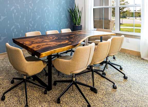 A wooden table with four chairs and a hanging light fixture.