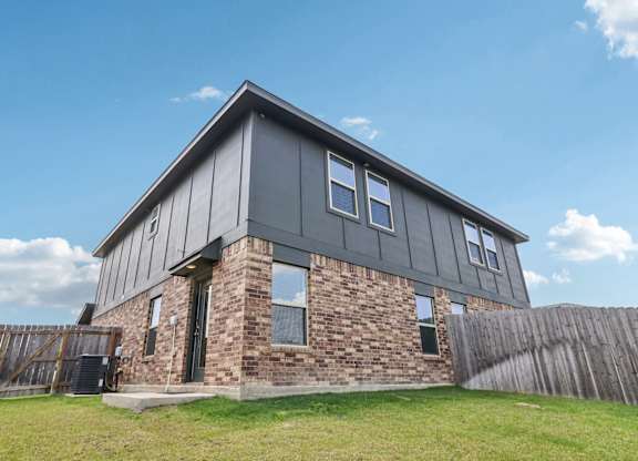 A house with a grey roof and a brick wall.