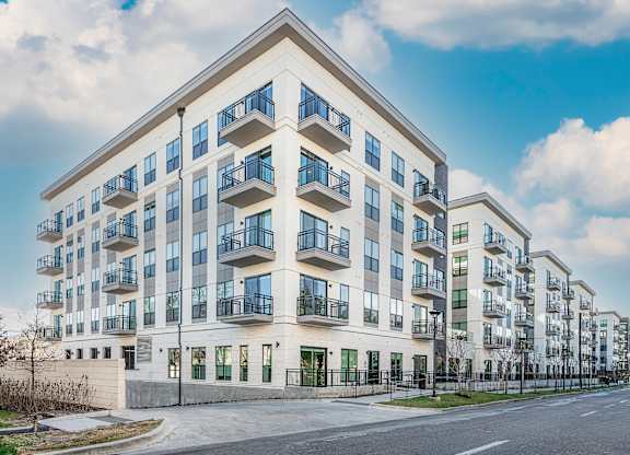 A modern apartment building with balconies and a clear sky.