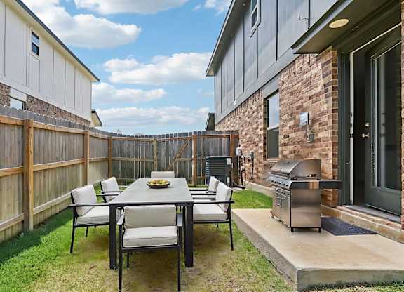 A backyard with a table and chairs.