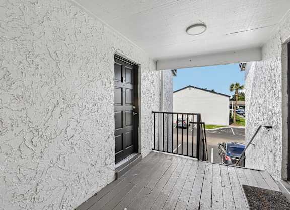 A balcony with a black railing and a wooden floor.