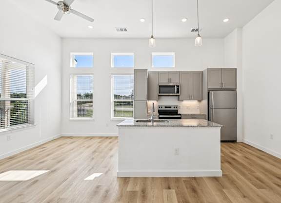 A modern kitchen with a large island and stainless steel appliances.