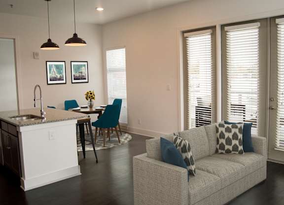 A modern kitchen with a dining table and a couch.