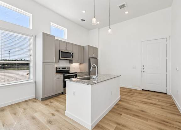 A kitchen with a sink, stove, and refrigerator.