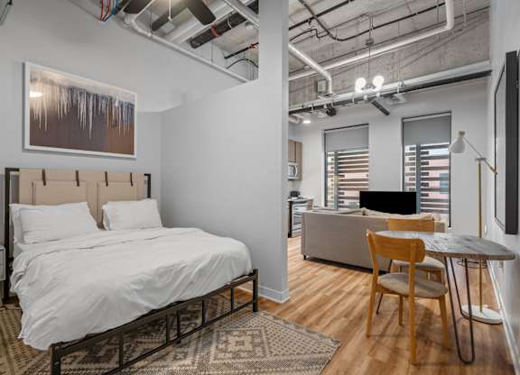 A bedroom with a bed, desk, and chair.