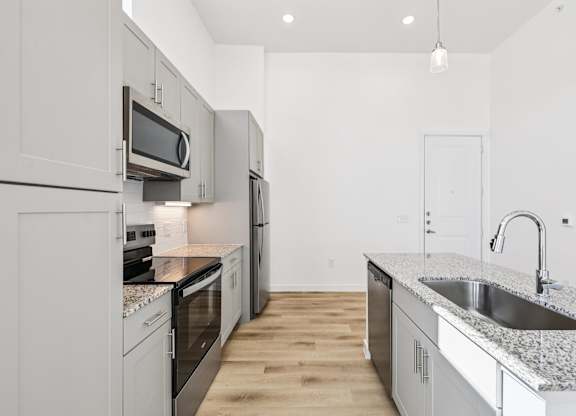 A kitchen with a granite countertop and stainless steel appliances.