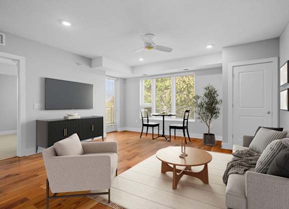 A living room with a grey couch, a wooden coffee table, and a television.