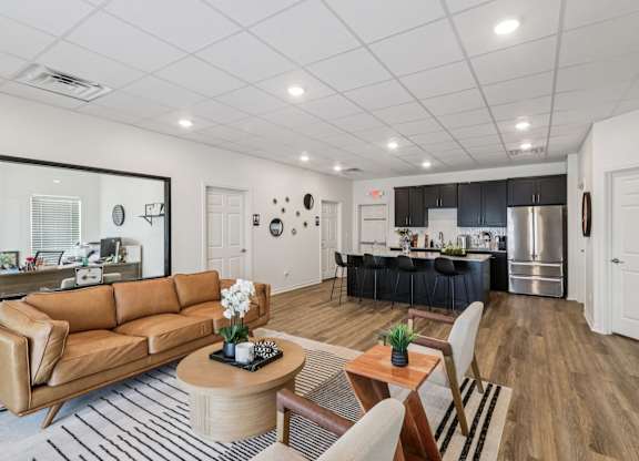 A modern living room with a brown leather couch and a wooden coffee table.