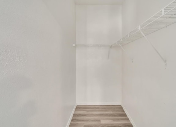 an empty room with white walls and a wood floor