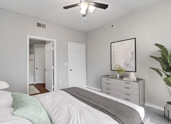 an empty bedroom with a bed and a ceiling fan