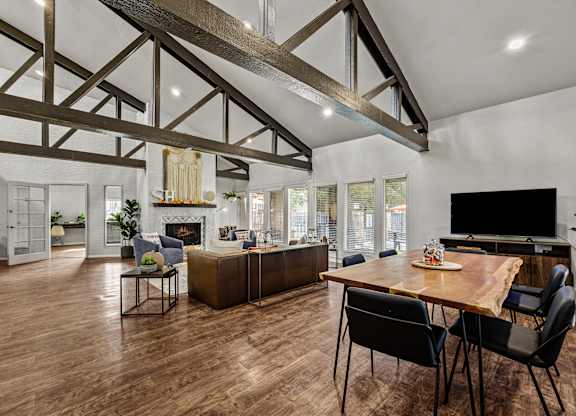 a living room with a dining room table and a tv