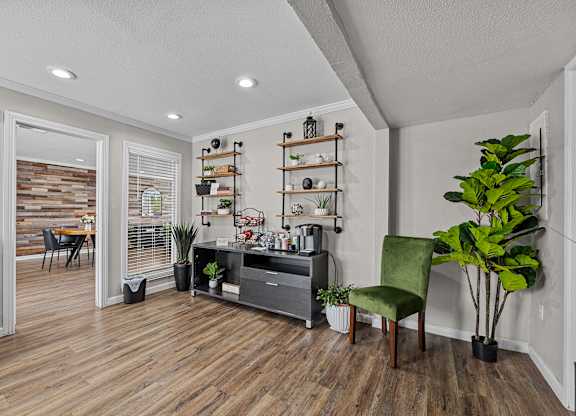 a living room with white walls and wood floors and a black entertainment center