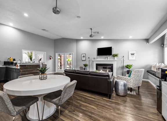 a living room with a table and chairs and a fireplace