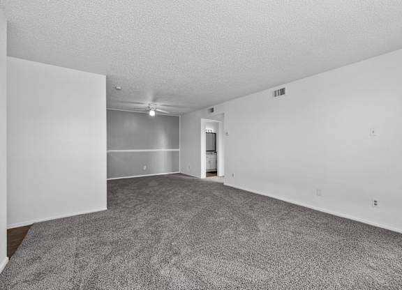 an empty living room with carpet and white walls