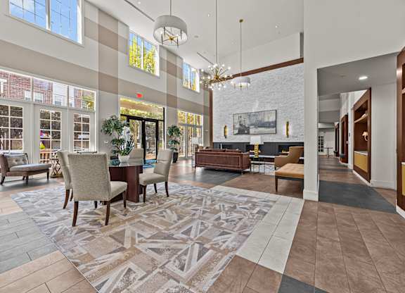 a large lobby with chairs and tables and a fireplace