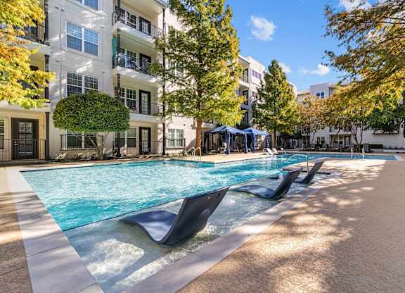 a swimming pool in front of an apartment building