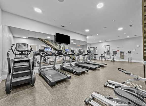 a gym with cardio equipment and treadmills