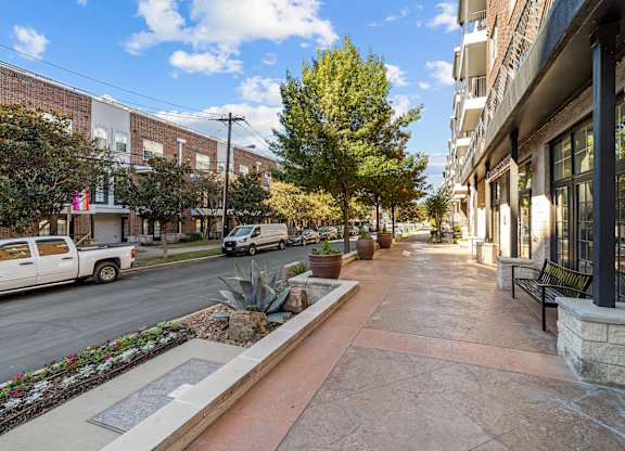 an empty sidewalk in front of a building on a city street